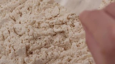 Beyaz protein tozuyla dolu bir kaşık çıkar. Spor besin takviyesi, sağlıklı beslenme, kas iyileştirme konsepti. Vanilyalı süt tozu. Vücut geliştirme spor salonu yaşam tarzı