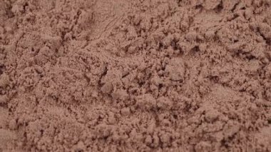 Çikolata protein tozuna yakın çekim. Dönen dokulu arka plan. Fitness, sağlıklı beslenme, kas gelişimi ve vücut geliştirme konsepti için spor takviyesi. Beyaz yağlı protein. Spor salonu yaşam tarzı