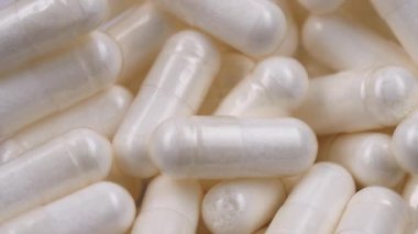 Dönen makro beyaz kapsüller, diyet takviyeleri. Eczacılık üretimi. Tıp ve sağlık, tedavi, önleme ve sağlık kavramı. Haplar ve vitaminler makro.