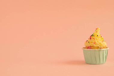 Mercan desenli arka planda tereyağı kremalı bir doğum günü pastasının yan görünüşü.