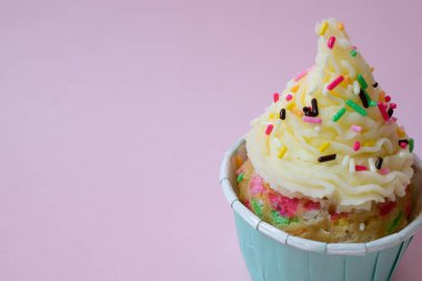 Pembe arka planda tereyağlı kremalı bir doğum günü pastasının kapağını kapat.