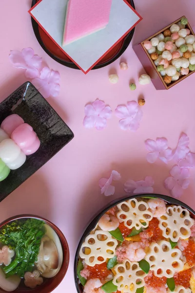 분홍빛 배경에는 초밥이 흩어져 것처럼 소녀의 기념하기 전통적 음식이 — 스톡 사진