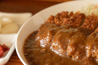 Japon köri yahnisini beyaz bir kasede domuz pirzolası ile kapat..