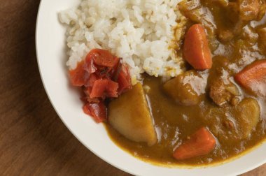 Japon domuz eti, beyaz bir tabakta servis edilir. Soya soslu dilimlenmiş turplar, ahşap bir masada, üst manzara..