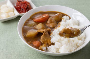 Japon domuz eti, beyaz bir tabakta servis edilir, üzerine tatlı ve ekşi soğan turşusu ve soya sosu ile dilimlenmiş turplar, ahşap bir masada, üst manzara..