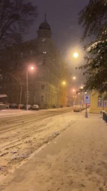 Şehirde kış gecesi Şiddetli kar yağışı sırasında Parlayan sokak lambalarıyla