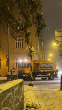 Kar temizleme kamyonu şehir bölgesinde kış fırtınasında sokakları temizliyor.