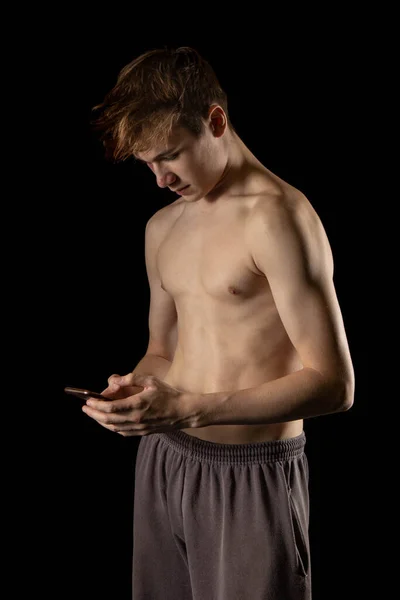 Sedmnáctiletý Svalnatý Kluk Bez Trička Držící Mobilní Telefon — Stock fotografie