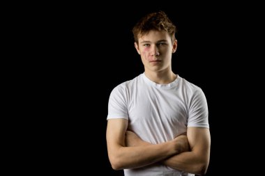 Headshot of a 17 year old boy wearing a white t-shirt against a black background