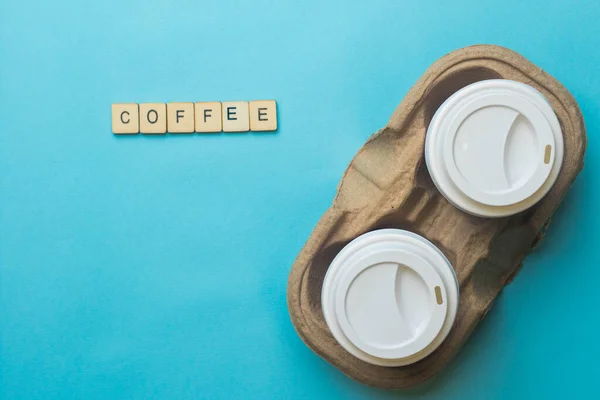 Een Karton Met Papieren Koffiekopjes Deksels Met Een Bordje Koffie — Stockfoto