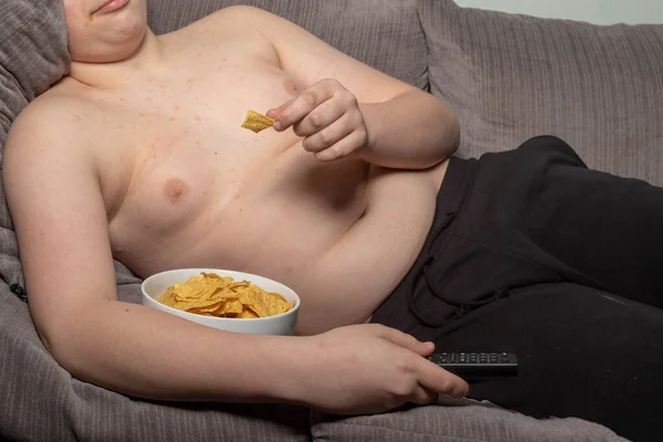 Overweight Caucasian Teenage Boy Laying Sofa Watching Crisps — Stock Photo, Image