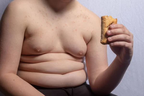 一个体重超标的高加索少年在吃香肠卷 — 图库照片