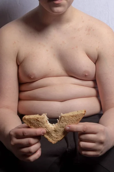 一个体重超标的高加索少年在吃三明治 — 图库照片