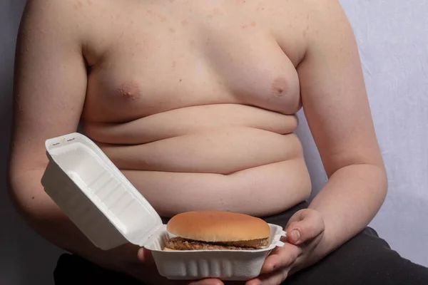 Een Overgewicht Blanke Tiener Jongen Met Een Afhaalhamburger — Stockfoto