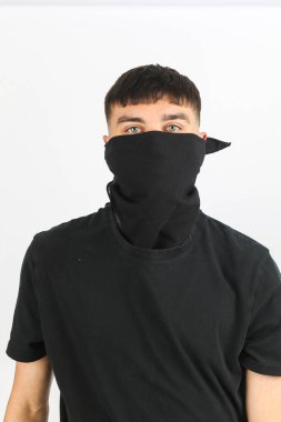 Beyaz arka planda siyah bir maske takan genç bir çocuk.