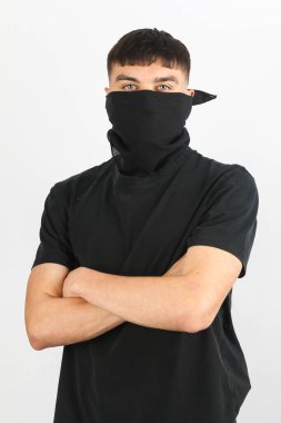 Beyaz arka planda siyah bir maske takan genç bir çocuk.