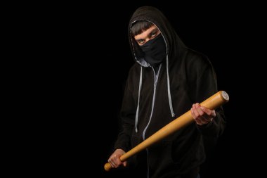 Siyah maskeli, kapüşonlu ve beysbol sopalı genç bir çocuk.