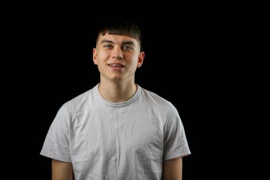 Siyah bir arka planda genç bir çocuğun portresi.