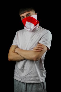 İngiltere bayraklı bir maske takan genç bir çocuk ve siyah bir arka plana karşı kollarını kavuşturmuş.