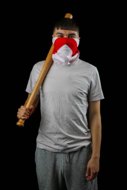 Siyah arka planda beyzbol sopası taşıyan İngiltere bayrağı taşıyan bir genç çocuk.