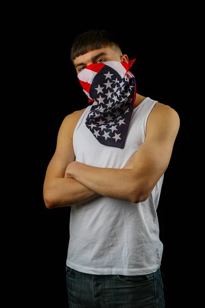 黒の背景にアメリカの旗のマスクを持つ白いベストの十代の男の子 — ストック写真