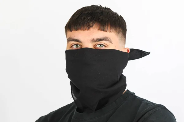 stock image Teenage boy wearing a black mask against a white background