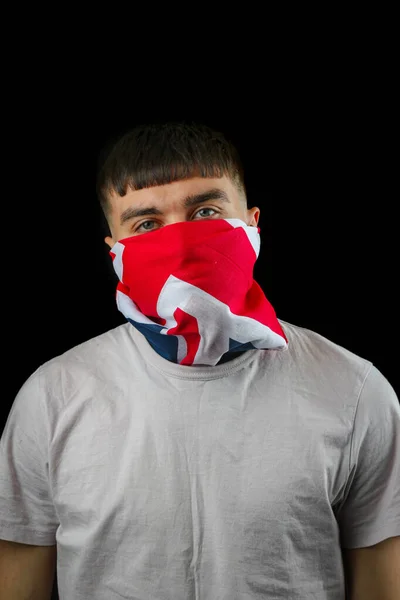 若いです男の子身に着けています黒の背景に英国の旗のマスク — ストック写真