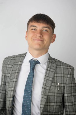 Genç girişimci takım elbise ve kravat takmış gülümsüyor ve gülüyor.