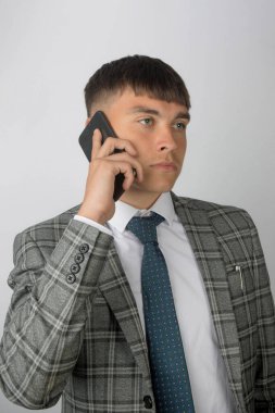 Genç girişimci takım elbiseli ve kravatlı telefon görüşmesi yapıyor.