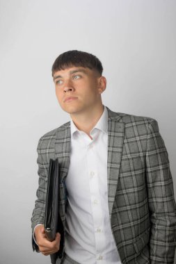 Takım elbiseli genç bir girişimci ve kravatı olmayan açık yakalı bir gömlek giyiyor.