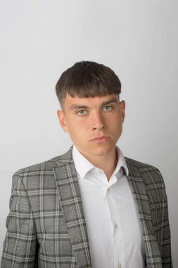 Takım elbiseli, kravatsız ve kravatsız genç bir girişimci endişeli görünüyor.