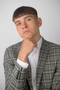 Takım elbiseli genç bir girişimci ve eli çenesinde kravatı olmayan açık bir yaka gömlek giyiyor. Düşünme