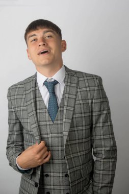 Takım elbise, kravat ve yelek giyen genç girişimci gülümsüyor.