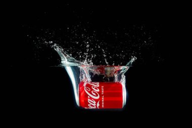 Londra, Birleşik Krallık, 24 Temmuz 2023: Bir kutu Coca-Cola siyah arka planda suya sıçrıyor