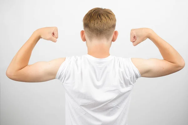 Teenage boy flexing his back muscles isolated on a white