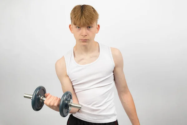ダンベルを使用して袖のないベストを身に着けている14歳の白人十代の少年肖像画 — ストック写真