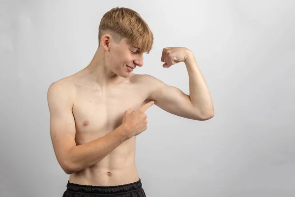 Retrato Adolescente Sin Camisa Deportivo Flexionando Bíceps Mientras Señala — Foto de Stock