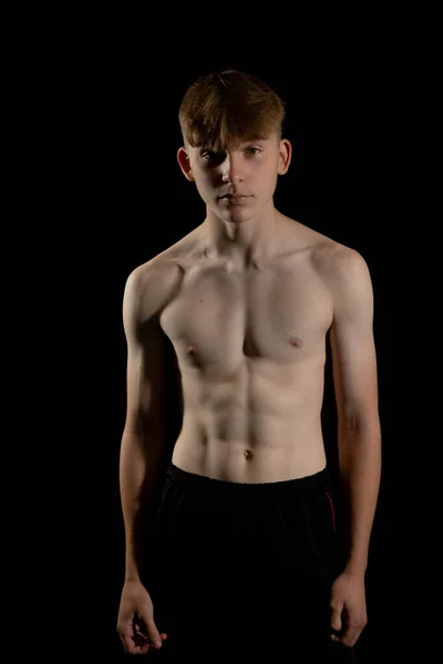 スポーティシャツレスティーンエイジャーの男の子の肖像画彼の筋肉を柔らかく — ストック写真