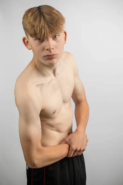 근육을 구부리는 스포티 셔츠가없는 소년의 초상화 — 스톡 사진