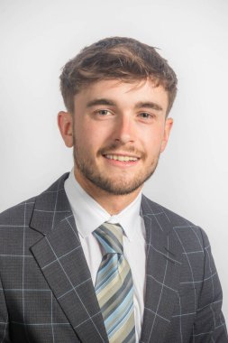 Takım elbiseli gülümseyen genç bir girişimcinin portresi ve düz bir arkaplan üzerine kravat.