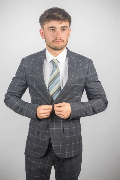 スーツで若い起業家の肖像画とジャケットを平凡な背景に調整するネクタイ — ストック写真