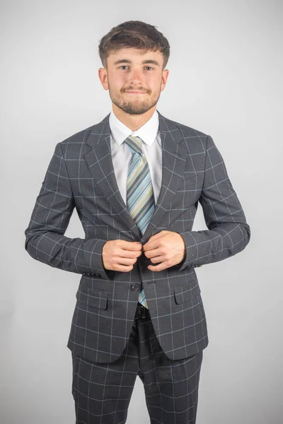 はっきりとした背景に対してスーツを調整する若い起業家の肖像画 — ストック写真