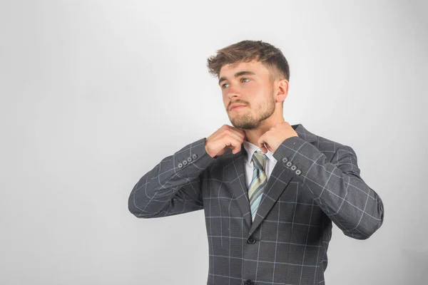 Portrait Young Entrepreneur Suit Tie Adjsuting His Collar Plain Background — Stock Photo, Image