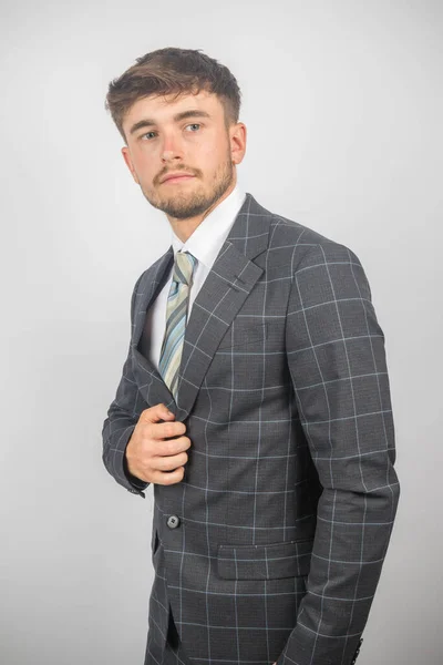 スーツの若い起業家の肖像画とジャケットを平凡な背景に保持するネクタイ — ストック写真