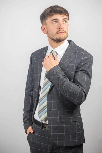 Portrait Young Entrepreneur Suit Adjusting His Tie Plain Background — Stock Photo, Image