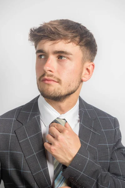 Portrait Young Entrepreneur Suit Adjusting His Tie Plain Background — Stock Photo, Image