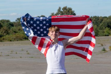 Formda ve sportif genç bir çocuk sıcak bir yaz gününde dışarıda şınav çekiyor.