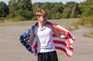 Formda ve sportif genç bir çocuk sıcak bir yaz gününde dışarıda şınav çekiyor.