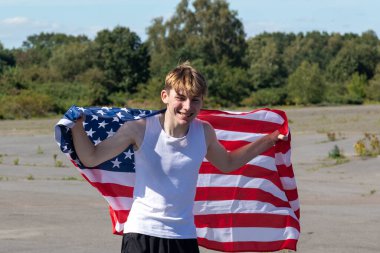 Formda ve sportif genç bir çocuk sıcak bir yaz gününde dışarıda şınav çekiyor.