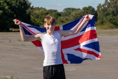 Formda ve sportif genç bir çocuk sıcak bir yaz gününde dışarıda şınav çekiyor.